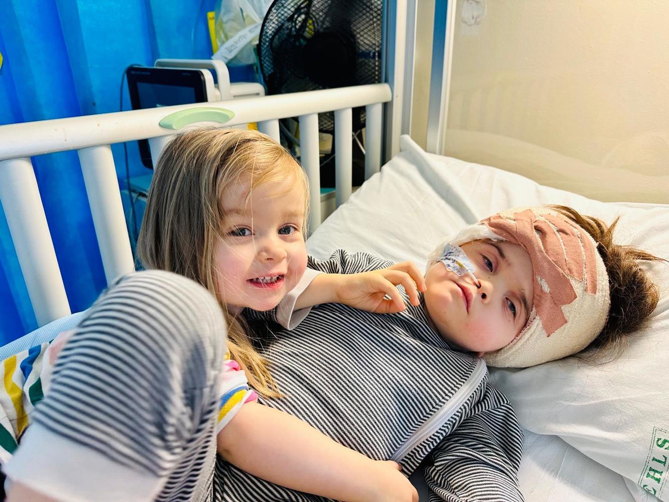 little girls hugs her sister afte surgery